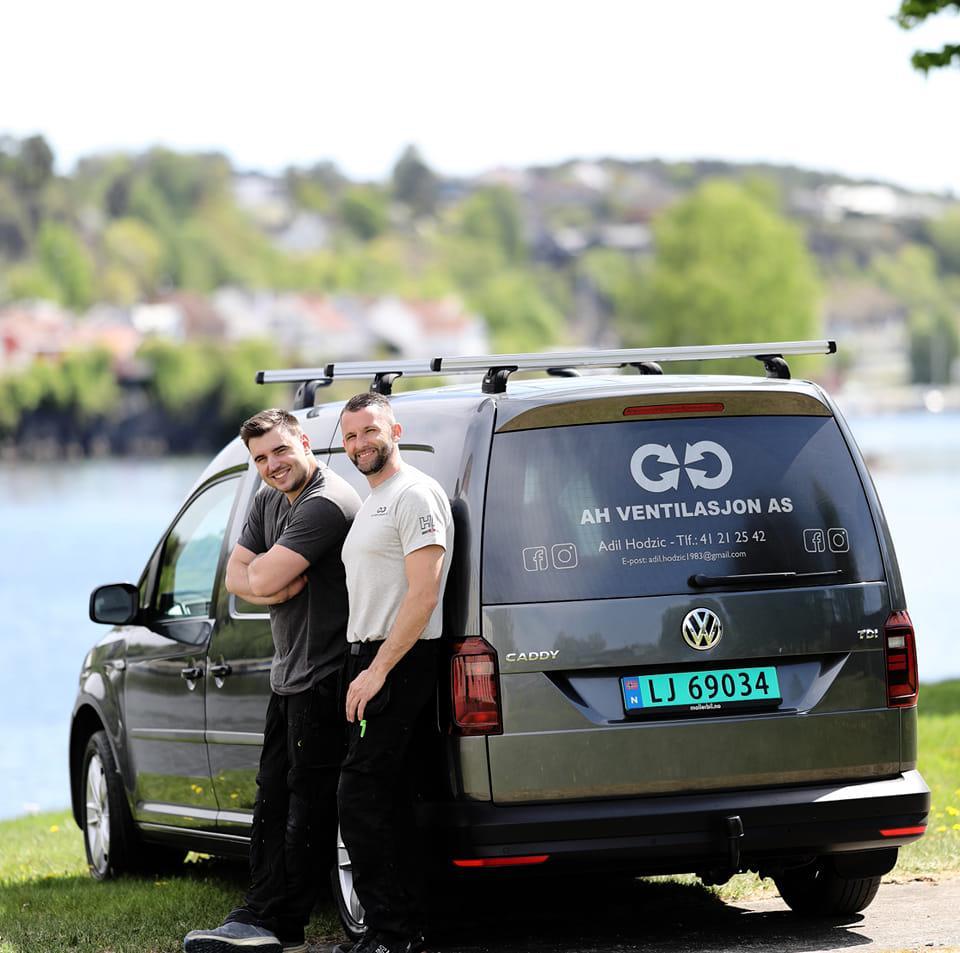 Arbeidsbil med to smilende menn foran