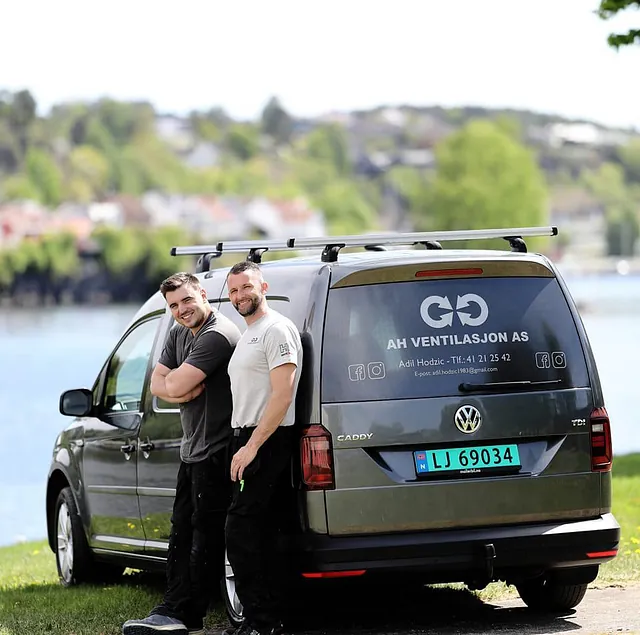 Arbeidsbil med to smilende menn foran